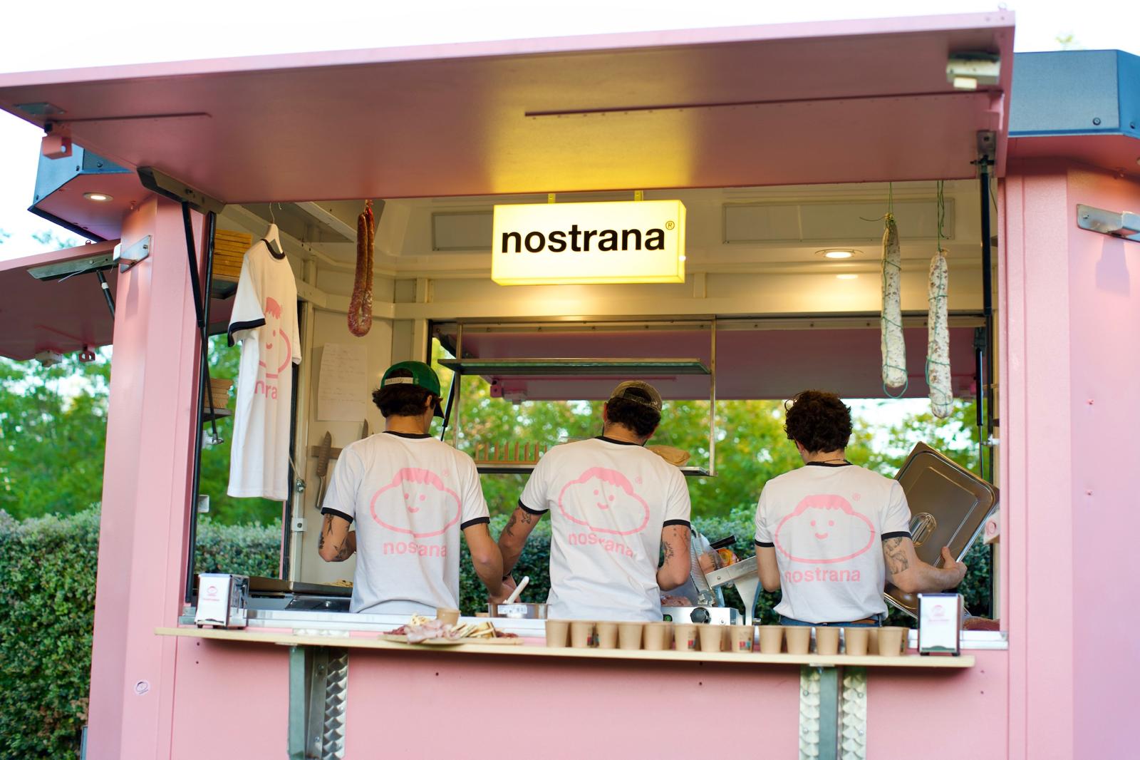 Il team Nostrana di spalle al lavoro nel food truck rosa